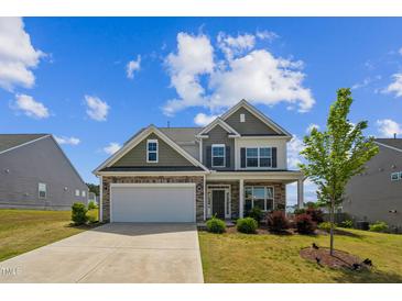 Two-story home featuring stone accents, neutral siding, and a two-car garage at 115 Bourne Dr, Franklinton, NC 27525