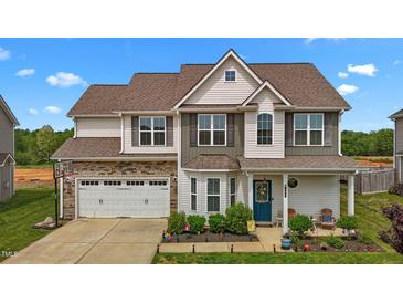 Charming two-story home features a two-car garage, landscaped yard, and a welcoming front porch at 135 Campaign Dr, Mebane, NC 27302