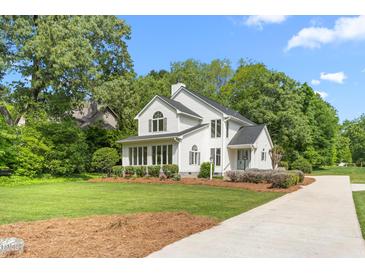 Stunning two-story white home boasting lush landscaping and a charming, curved driveway at 1925 W Lake Dr, Burlington, NC 27215