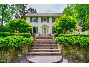 Stunning two-story home featuring stone steps leading to the main entrance and lush, mature landscaping at 220 Glandon Dr, Chapel Hill, NC 27514