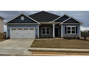 Charming single-Gathering home with a two-car garage, stone accents, and professionally landscaped yard at 244 Kipling Crk Dr, Fuquay Varina, NC 27526
