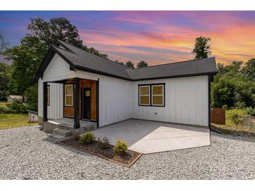 Charming home featuring a black roof, white siding, a cozy front porch, and a gravel yard at 2616 Wedgedale Ave, Durham, NC 27703