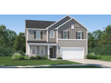 Charming two-story home featuring a two-car garage, gray siding and a well-manicured lawn at 4024 Shadbush St, Raleigh, NC 27616