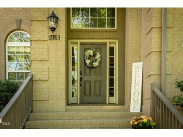 Charming home entrance with a wreath on the front door and a 'welcome' sign at 5129 Bartons Enclave Ln, Raleigh, NC 27613