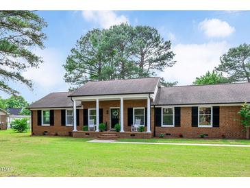 Charming red brick home with a covered front porch and well-manicured lawn, perfect for curb appeal at 603 Warren Rd, Erwin, NC 28339
