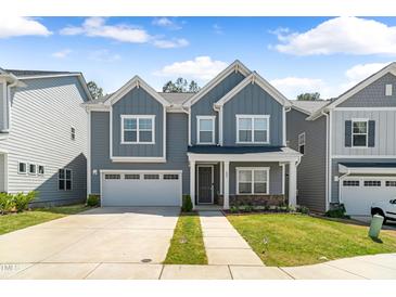 Charming two-story home with a well-manicured lawn and an attached two-car garage in a neighborhood setting at 608 Cormiche Ln, Wake Forest, NC 27587
