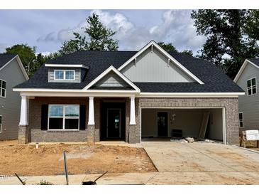 Charming single-story home featuring a brick facade, an attached two-car garage, and classic architectural detailing at 1085 Fairhaven Dr # 49, Mebane, NC 27302