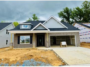 Charming new home featuring gray brick, a dormer window, and an attached two-car garage at 1085 Fairhaven Dr # 49, Mebane, NC 27302