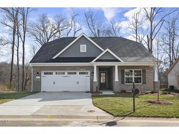 Charming single-story brick home featuring a two-car garage and a well-manicured front lawn at 1085 Fairhaven Dr # 49, Mebane, NC 27302