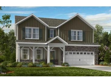 Charming two-story home featuring stone accents, a covered porch, and a two-car garage at 1125 Sun Springs Rd, Wake Forest, NC 27587