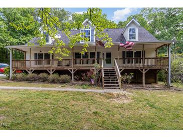 Charming two-story home with a covered porch and landscaped front yard surrounded by lush trees at 1176 Stoney Mountain Rd, Rougemont, NC 27572