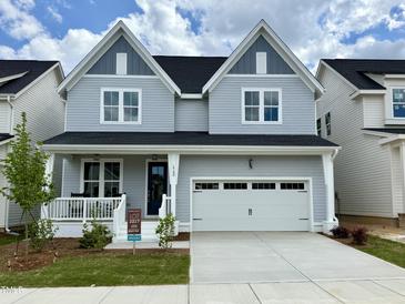 Charming two-story home with a front porch, a two-car garage, and a well-manicured lawn in a residential neighborhood at 1733 Birdhaven Ln, Wendell, NC 27591