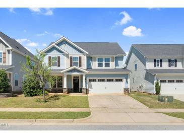 Charming two-story home featuring light blue siding, stone accents, a two-car garage, and a well-maintained lawn at 2008 Campana Dr, Raleigh, NC 27603