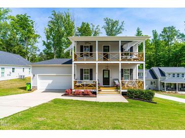 Charming two-story home featuring double balconies and a well-manicured front yard at 27 Ashley Woods Ct, Clayton, NC 27527