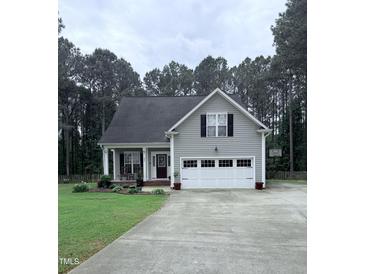 Charming home with a two-car garage, well-manicured lawn, and inviting front porch at 282 W Thicket Dr, Angier, NC 27501