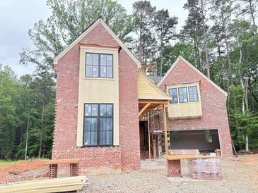 Two-story brick home with black-framed windows under construction with architectural details at 3324 Founding Place, Raleigh, NC 27612