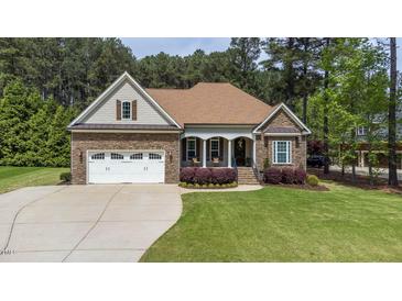 Charming stone and siding home with well-manicured lawn and attached two car garage at 3612 Griffice Mill Rd, Raleigh, NC 27610