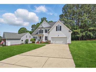 Charming two-story home with attached two-car garage, white siding, and well-manicured lawn at 4418 Gallatree Ln, Raleigh, NC 27616