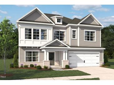 Charming two-story home with gray siding, white trim, a two-car garage, and a well-manicured lawn at 560 Jocund St # 12, Rolesville, NC 27571