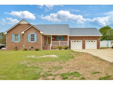 Charming single-story brick home featuring a manicured front lawn and attached garage at 6042 Elliott Bridge Rd, Linden, NC 28356