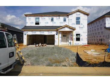 Exterior of new two-story home with Tyvek HomeWrap in the process of being built showing its framing and structure at 640 White Birch Ln, Angier, NC 27501