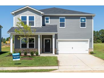 Charming two-story home with gray siding, a two-car garage, and a well-manicured front yard at 677 White Birch Ln, Angier, NC 27501
