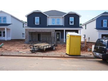 New two-story home features a brick-facade garage and modern, dark blue siding on the upper level at 741 Deschutes Dr, Garner, NC 27529