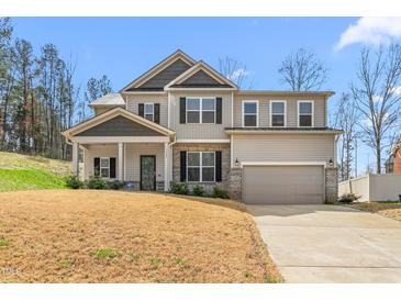 Beautiful two-story home featuring a welcoming covered porch, a two-car garage, and professionally landscaped front yard at 1009 Haynoke Dr, Graham, NC 27253