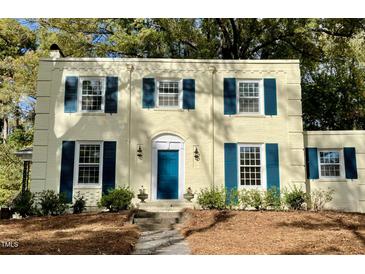 Charming two-story home with a blue front door and manicured landscaping at 112 Hilton Ave, Durham, NC 27707