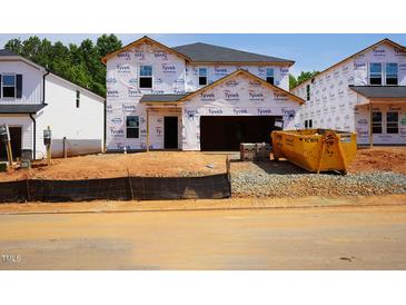 New home construction with Tyvek wrap, showcasing the early stages of the build at 1139 Winding Spring Dr, Mebane, NC 27302