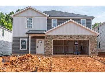 Two-story home featuring stone accents, two-car garage, and neutral-colored siding at 1139 Winding Spring Dr, Mebane, NC 27302