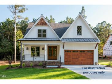 Charming two-story home featuring a manicured lawn, double-door entrance, and a striking two-car garage at 12845 Mallard Rock Rd, Zebulon, NC 27597