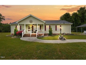 Charming single-story home featuring a covered front porch and well-manicured lawn at 1510 Asbury Church Rd, Sanford, NC 27330