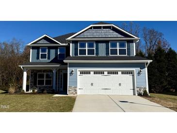 Beautiful two-story home with blue siding, stone accents, and a spacious two-car garage at 1667 Pecan Drive # 25, Nashville, NC 27856