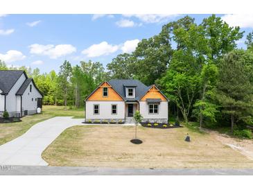 Charming exterior view of home with a well-manicured lawn, driveway, and tasteful landscaping at 310 Pilot Ridge Rd, Zebulon, NC 27597