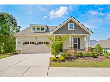 Charming home featuring a two-car garage, beautiful landscaping, and welcoming covered entry at 3510 Tuftonboro Ln, Apex, NC 27502