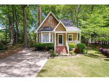 Charming home featuring a brick pathway leading to the front door and surrounded by mature trees at 4969 Royal Adelaide Way, Raleigh, NC 27604