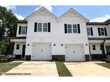 Charming townhome featuring a white exterior, a two-car garage and black trim at 51 Calluna Dr, Clayton, NC 27520