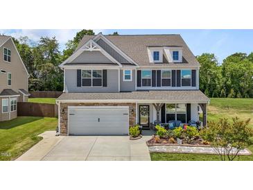 Beautiful two-story home featuring stone accents, a two-car garage, and a charming covered front porch at 528 Brycewood Dr, Burlington, NC 27215