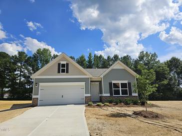 Charming single-story home with a two-car garage, landscaped yard, and a welcoming entrance at 79 Mildred Dr, Broadway, NC 27505