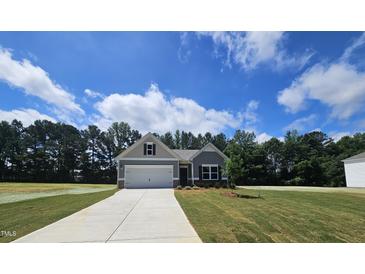 Charming home with a well-manicured lawn and a two-car garage, blending comfort and curb appeal at 79 Mildred Dr, Broadway, NC 27505