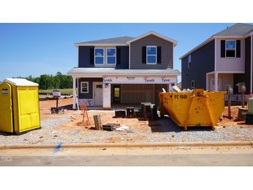 New home under construction with blue and gray siding, featuring a yellow dumpster at 801 Ottawa Dr, Garner, NC 27529