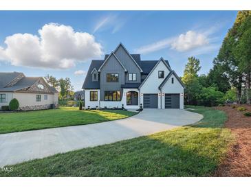 Stunning new construction featuring mixed siding, three-car garage, and manicured lawn at 833 Dunleigh Dr, Burlington, NC 27215