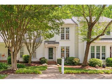 Charming white two-story home with lush landscaping and inviting front entrance at 104 Planetree Ln, Cary, NC 27511