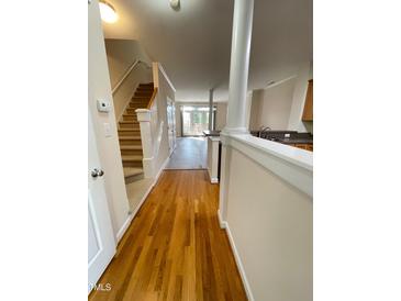 Inviting entryway with hardwood floors and staircase leading to upper level, complemented by natural light streaming in at 113 Conner Dv # 106, Chapel Hill, NC 27514