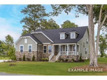 Charming single-story home featuring a stone facade, dormer windows, and inviting front porch at 137 Cultivator Ct, Angier, NC 27501