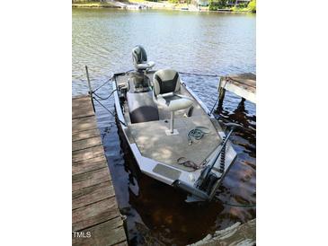 Docked Timemaker boat featuring grey carpet and chairs for a relaxing lake experience at 1605 Sagamore Dr, Louisburg, NC 27549