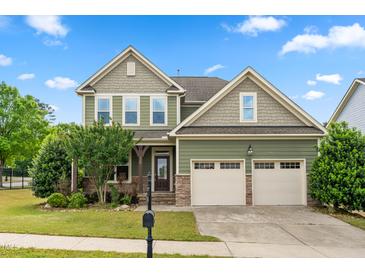 Charming two-story home featuring a two-car garage, stone accents, and a well-manicured lawn at 364 Springtime Fields Ln, Wake Forest, NC 27587