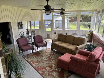 Inviting sunroom featuring comfortable seating, ceiling fans, and abundant natural light from large windows at 405 Taylor Dr, Rocky Mount, NC 27803