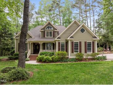 Charming, light green home featuring manicured lawn and mature landscaping at 406 Bakewell Ct, Wake Forest, NC 27587